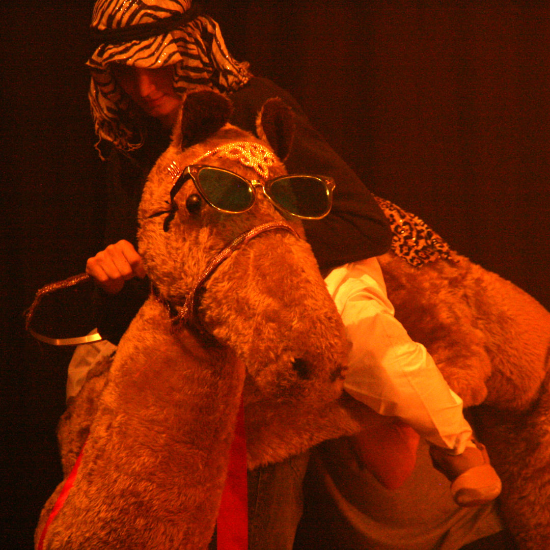 Backstage crew dressed as a camel on stage in Joseph