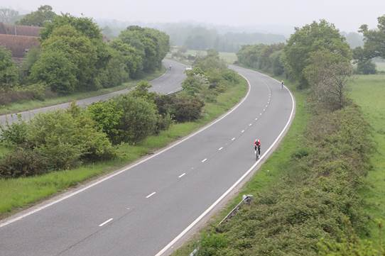 Cyclist on a long open road competing in a time trial